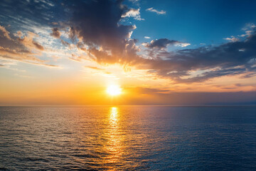Obraz premium Panoramic beach landscape. Royalty high-quality free best stock of a beautiful sunrise over the ocean with golden sunlight reflecting. Dramatic sky, sense of calm and tranquility