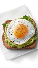 Savor the delightful combination of creamy avocado spread generously on whole grain bread, crowned with a perfectly cooked sunny-side-up egg