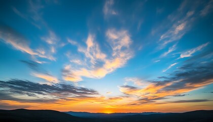 Obraz premium Vibrant Sunset Sky Over Silhouetted Mountain Range