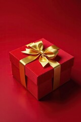 Obraz premium Red velvet background with golden bow on a decorative package, boxes, gold, wrapping paper