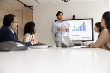 Serious motivated young speaker giving marketing presentation to business colleagues, partners,...