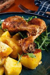 Baked chicken drumsticks with potatoes.