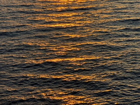 Sea water with sun golden reflections on surface
