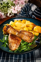 Baked chicken drumsticks with potatoes.