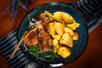 Baked chicken drumsticks with potatoes.
