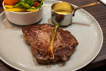 Large beef rib eye steak grilled on gas stove in German restaurant