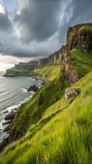 Naklejka premium Coastal landscape with rocky cliffs and vibrant grass under a dramatic cloudy sky showcasing nature's serene beauty and tranquility.