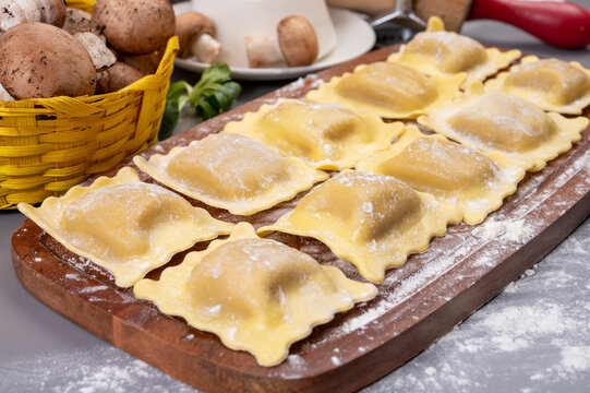 Italian food, fresh home made stuffed pasta ravioli dumplings with ricotta soft cheese and champignons porcini mushrooms, Parma, Emilia Romagna, Italy