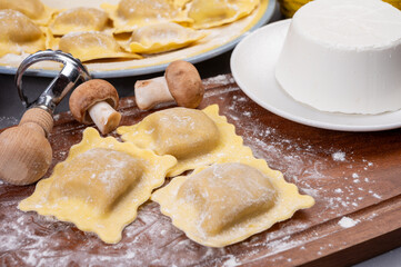 Italian food, fresh home made stuffed pasta ravioli dumplings with ricotta soft cheese and champignons porcini mushrooms, Parma, Emilia Romagna, Italy