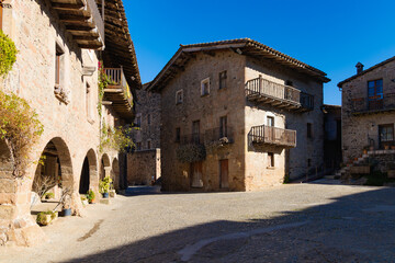 Plaza Mayor con porches de piedra, balcones y casas rústicas en Santa Pau, La Garrotxa.