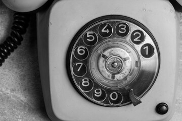 Vintage telephone on cement floor. Black and white tone.