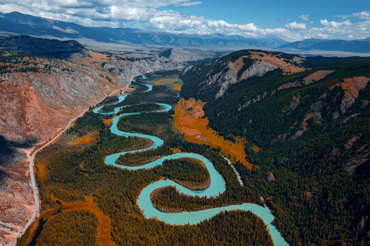 Beautiful aerial landscape winding river meander in mountains with forest trees with sunlight, Altai Russia, top view