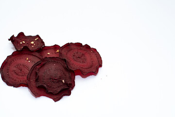 Slices, dried beetroot snacks on a light background, space for text, vegetarian food, healthy snacks, dried vegetables, selective focus.