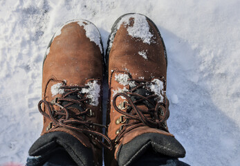 man wearing leather hiking boots covered in fresh snow after blizzard snowfall (brown work boot with blue jeans winter) snowy hike outdoor northeast united states white ice frozen powder skiing men's