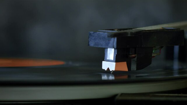 Close-up of a vintage record player needle playing a vinyl record, bringing analog music to life. Music video loop, with retro and old style aesthetic.