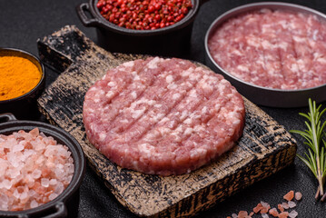 Fresh raw ground beef or pork burger patty with salt and spices