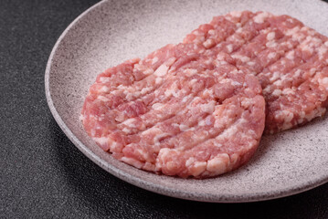 Fresh raw ground beef or pork burger patty with salt and spices