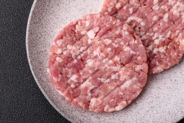 Fresh raw ground beef or pork burger patty with salt and spices
