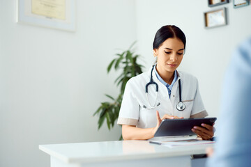 Professional Female Doctor Using Digital Tablet in Modern Medical Office