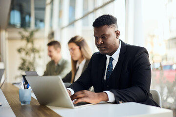 Professional Man Working on a Laptop in a Modern Office Environment