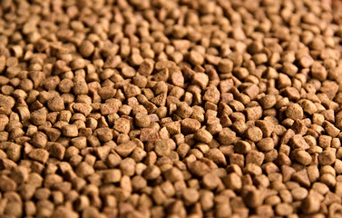 Dry pet food background. Pile of granulated animal feeds. Granules of good nutrition for dogs and cats.