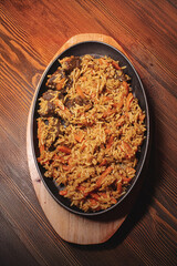 Pilaf in beautiful dishes is on the table in the restaurant. Food served on a stylish black plate