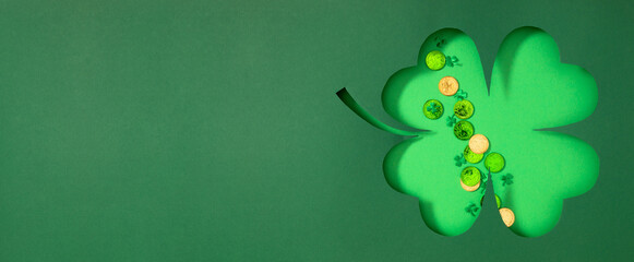 St. Patrick's Day concept. Green paper cutout shamrock shape with minimal themed decoration, green...