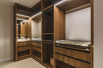 an image of an open illuminated walk in closet wardrobe in luxury mediterranean real estate