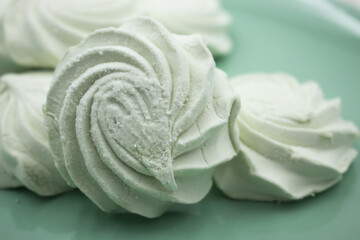 Light green apple marshmallows on a light green plate, close-up