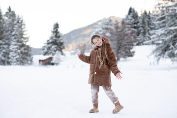 Cute little girl in winter walks in winter snow-covered forest. Winter Activities, Pastime, Walk