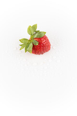 top shot on white photo background lies one ripe strawberry in the center of the background drops of water healthy vitamins seasonal summer fruit vitamin C green strawberry tail like a crown