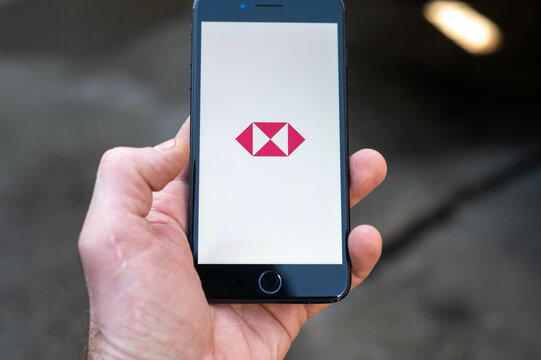person holding smartphone with HSBC bank app