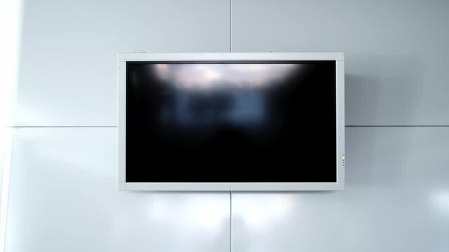 Modern flat screen lcd TV or oled, black screen blank HD monitor. Turned off display board on grey wall background in public place. Non-working television. Widescreen scoreboard. Advertising panel. 4K