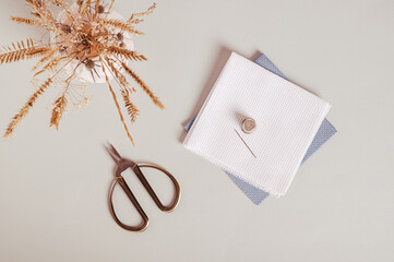 Canvas, needle, thimble and scissors for cross stitching on gray background top view