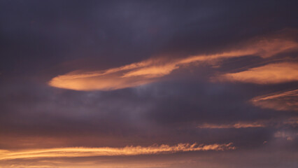 Landscape with dramatic clouds over the ocean, orange sunset