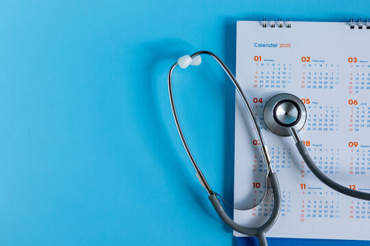 close up top view on stethoscope on calendar with over blue background for design about ads or banner of doctor appointment and health checkup following personal lifestyle concept