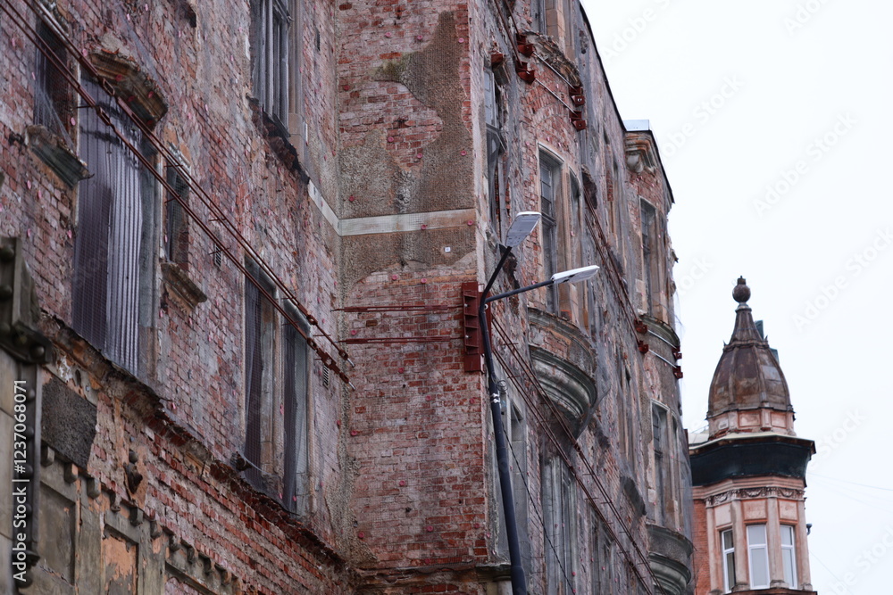 Aufkleber a tall brick building with a clock on its side, perfect for use in cityscape or architectural design