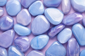Glossy opal pebbles in pastel lavender and baby blue colors, arranged to create an abstract pattern. The glossy texture of the stones adds depth and vibrancy against a soft purple background