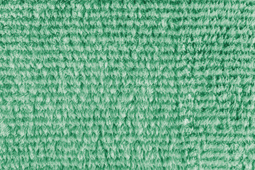 Terry cloth, striped pattern green towel texture background. Soft fluffy textile bath or microfiber beach towel material. Top view, close up, macro.