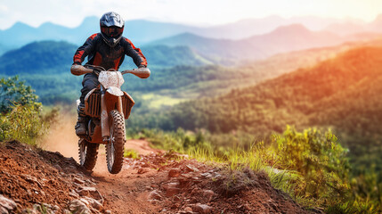 Naklejka premium Biker in Off-Road Gear Climbing a Steep Hill on a Rugged Dirt Trail, with a Blurred Mountain Range Creating a Dramatic Backdrop for an Adventurous Ascent