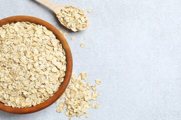 Composition with oatmeal flakes on gray background. Cooking breakfast