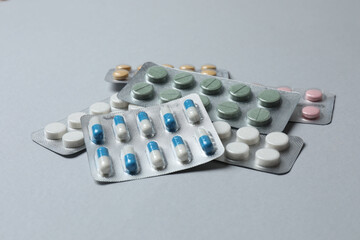 Pills in blister packs on gray  background, close up