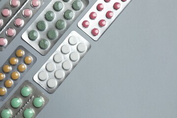 Pills in blister packs on gray  background, close up