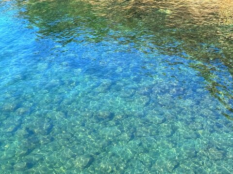 Seawater sea clear water with pebbles and stones underwater. 