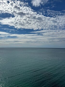 Clouds above blue shiny sea 