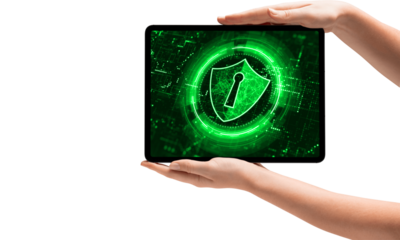 hands on a white background holding ipad.  Ipad shows green shield with padlock. Online security, data protection. Image ideal for tech articles websites about cyber security. 
