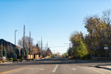 Lakewood, Colorado Rocky mountains small town in Applewood Denver area with road cars and blue sky morning landscape in neighborhood