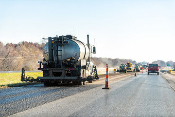 Cars in traffic on road street highway in Missouri with construction workers and machines leveling asphalr