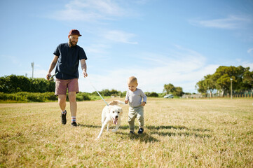 Happy, field and baby with dog and father for playing, having fun and adventure in countryside. Childhood, family pet and happy boy and dad outdoors for games on holiday, summer vacation and weekend