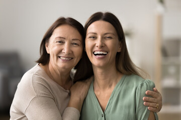 Close up portrait of happy elderly woman and her daughter, two beautiful different age, generations...